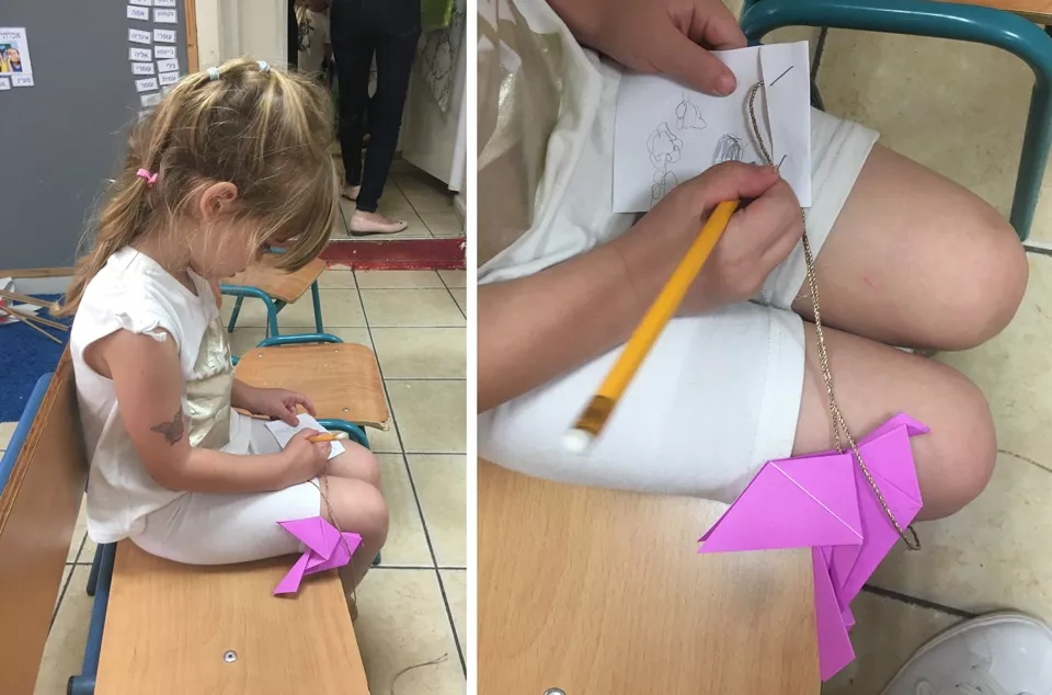 מעיין כותבת ברכה על ציפור האוריגמי שלה